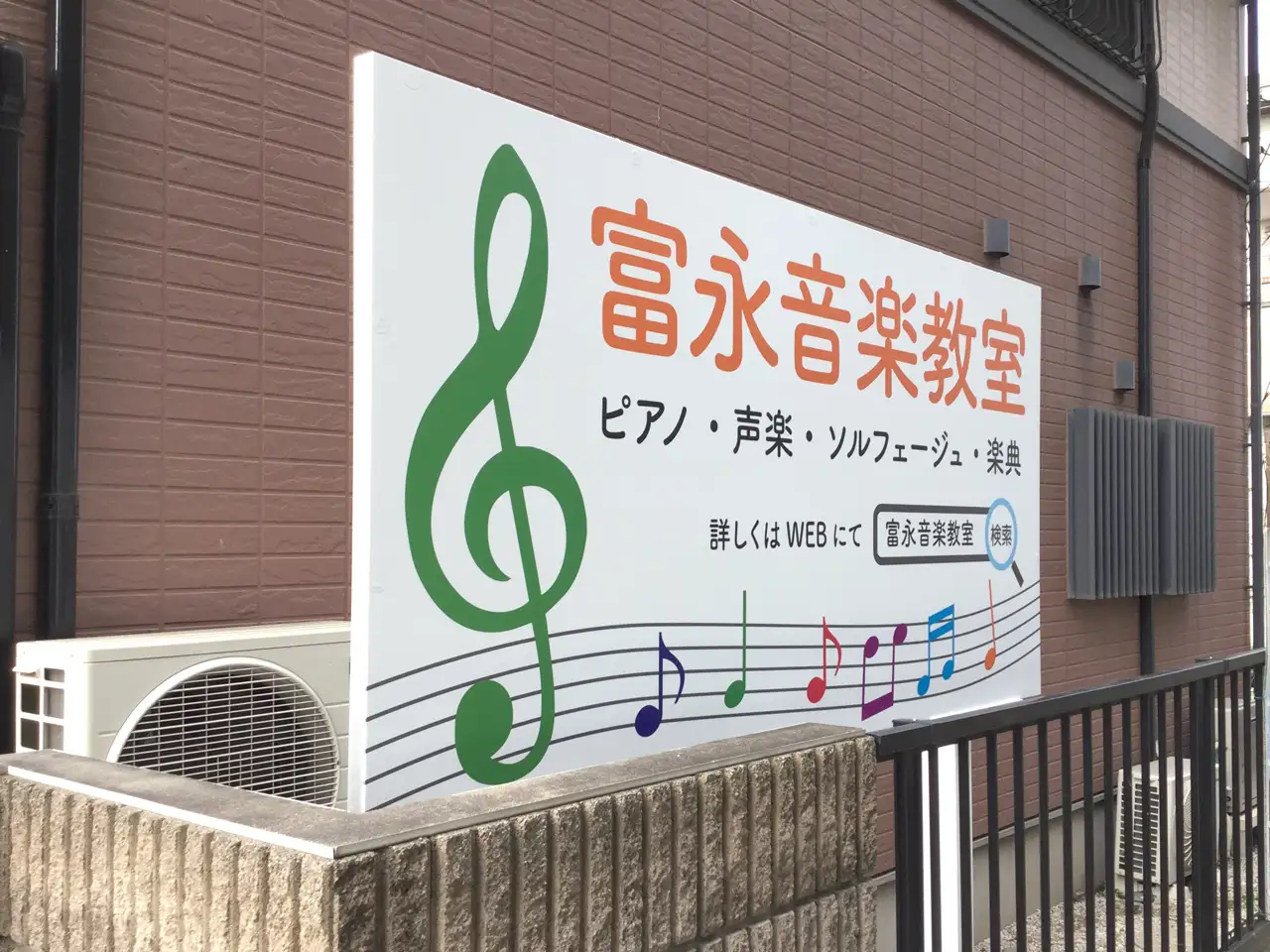 新しくきれいになった冨永音楽教室の野立看板