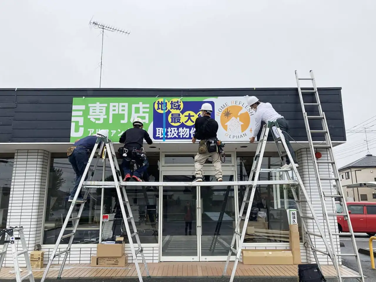 ファサードにプレート看板を設置しているところ