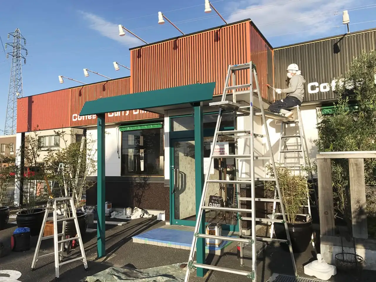 店舗壁面のルーバーを塗装しているところ