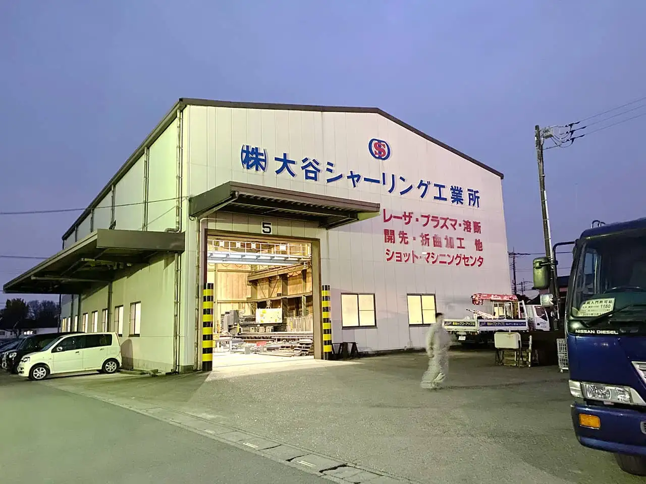 夕暮れの中浮き上がる作業所と壁面のカルプ文字