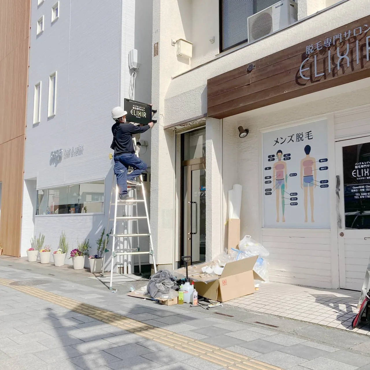 脚立にのぼり袖看板を取り付け中