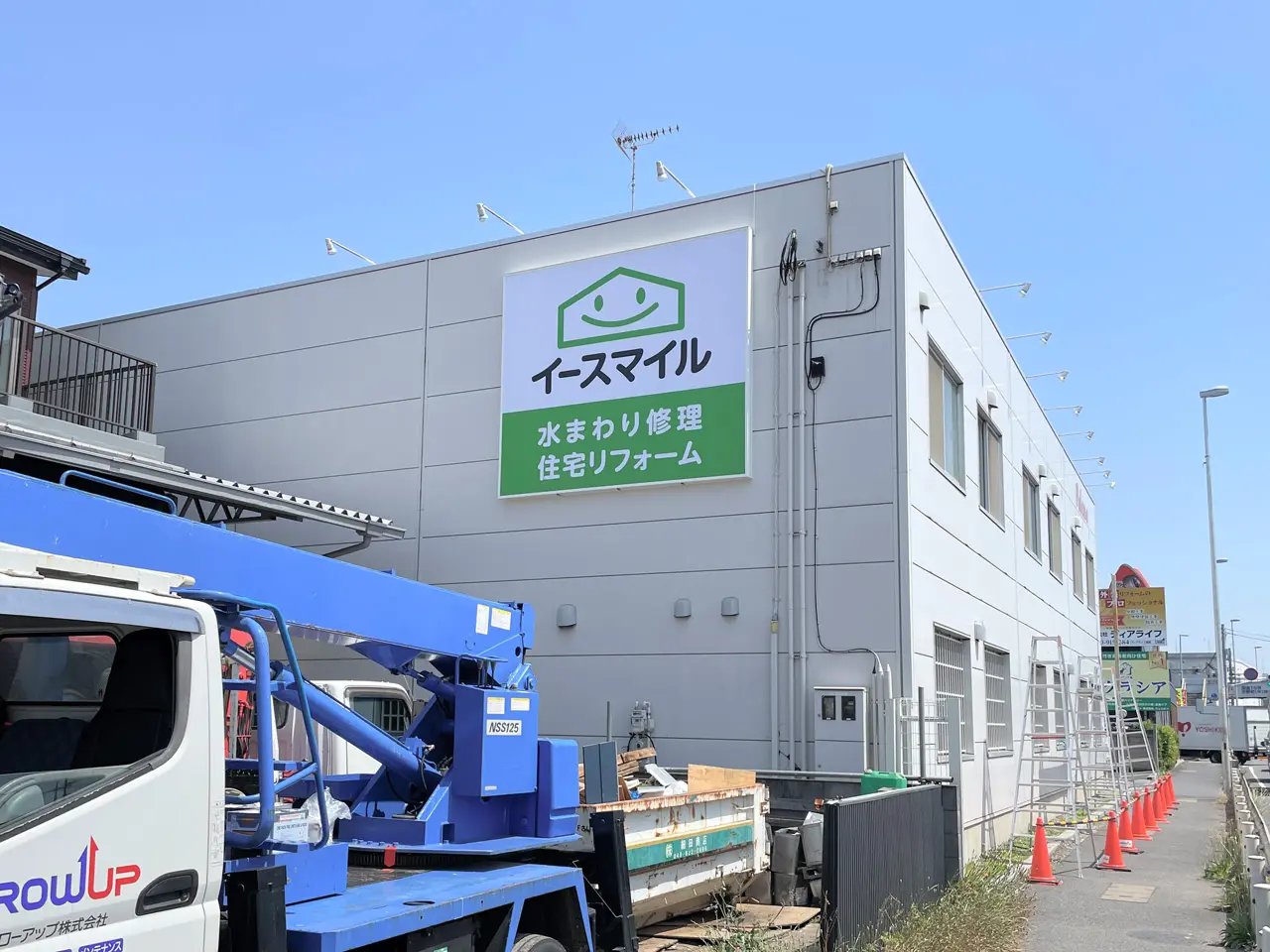 壁面に設置された内照式看板とアーム式の照明