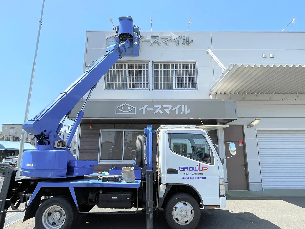 高所作業車でチャンネル文字を設置しているところ