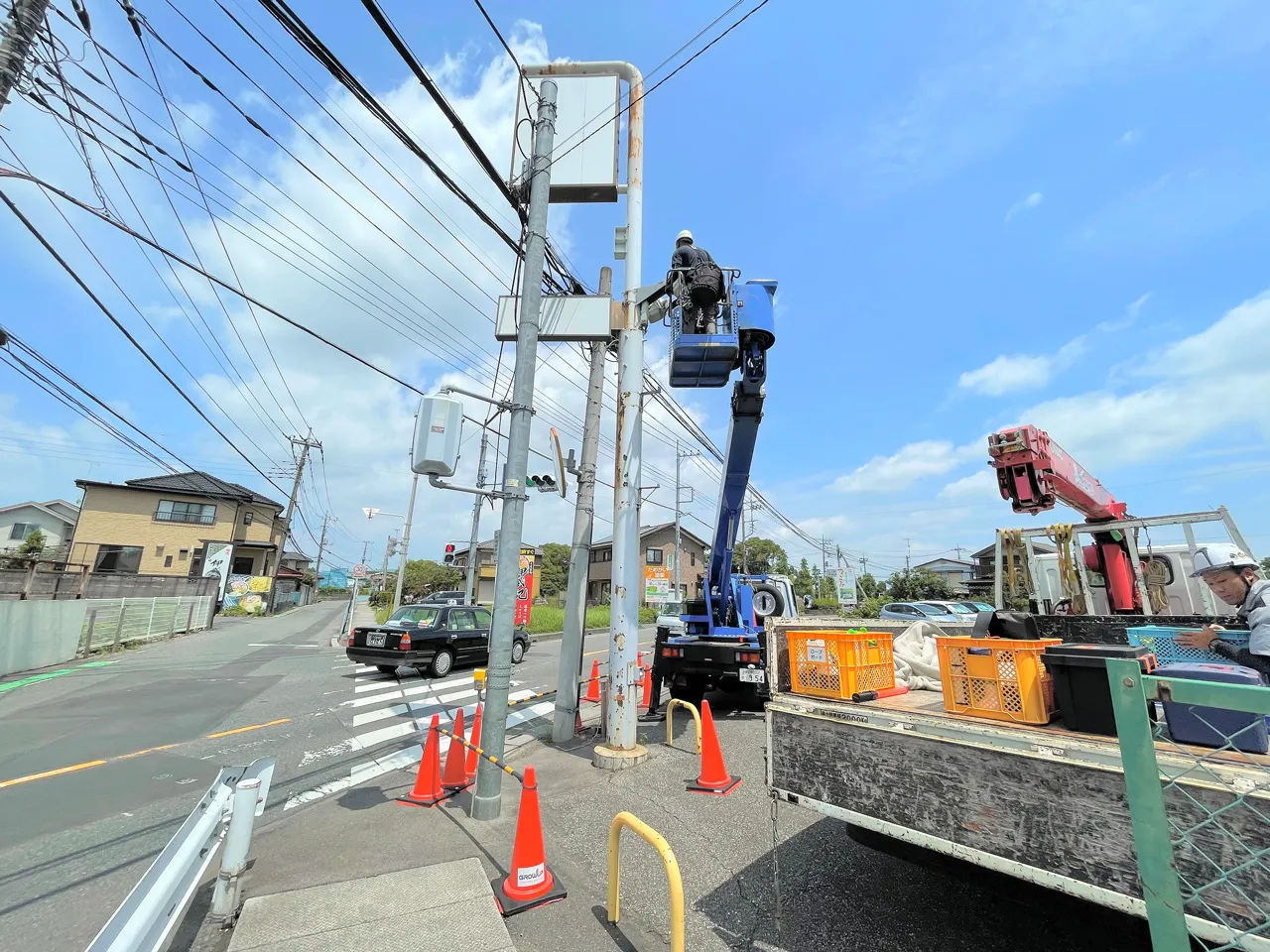 高所作業車で自立看板を施工しているところ