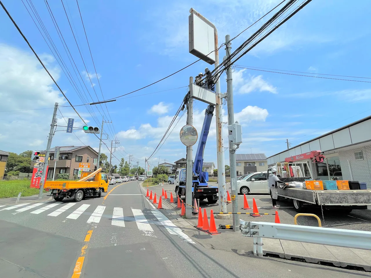 高所作業車で自立看板を施工しているところ