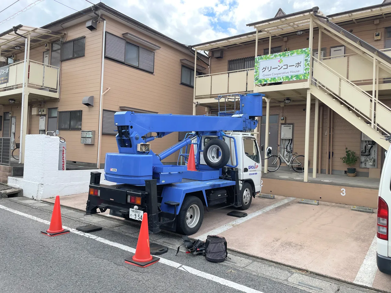 高所作業車でプレート看板を貼り終えたところ