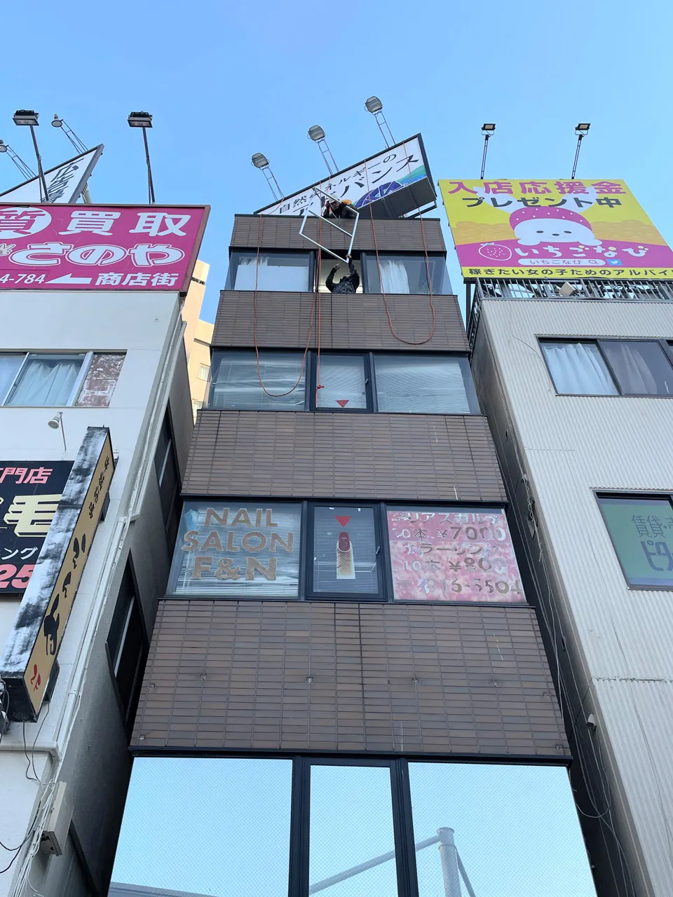 アルミフレームを窓から屋上へ上げてるところ