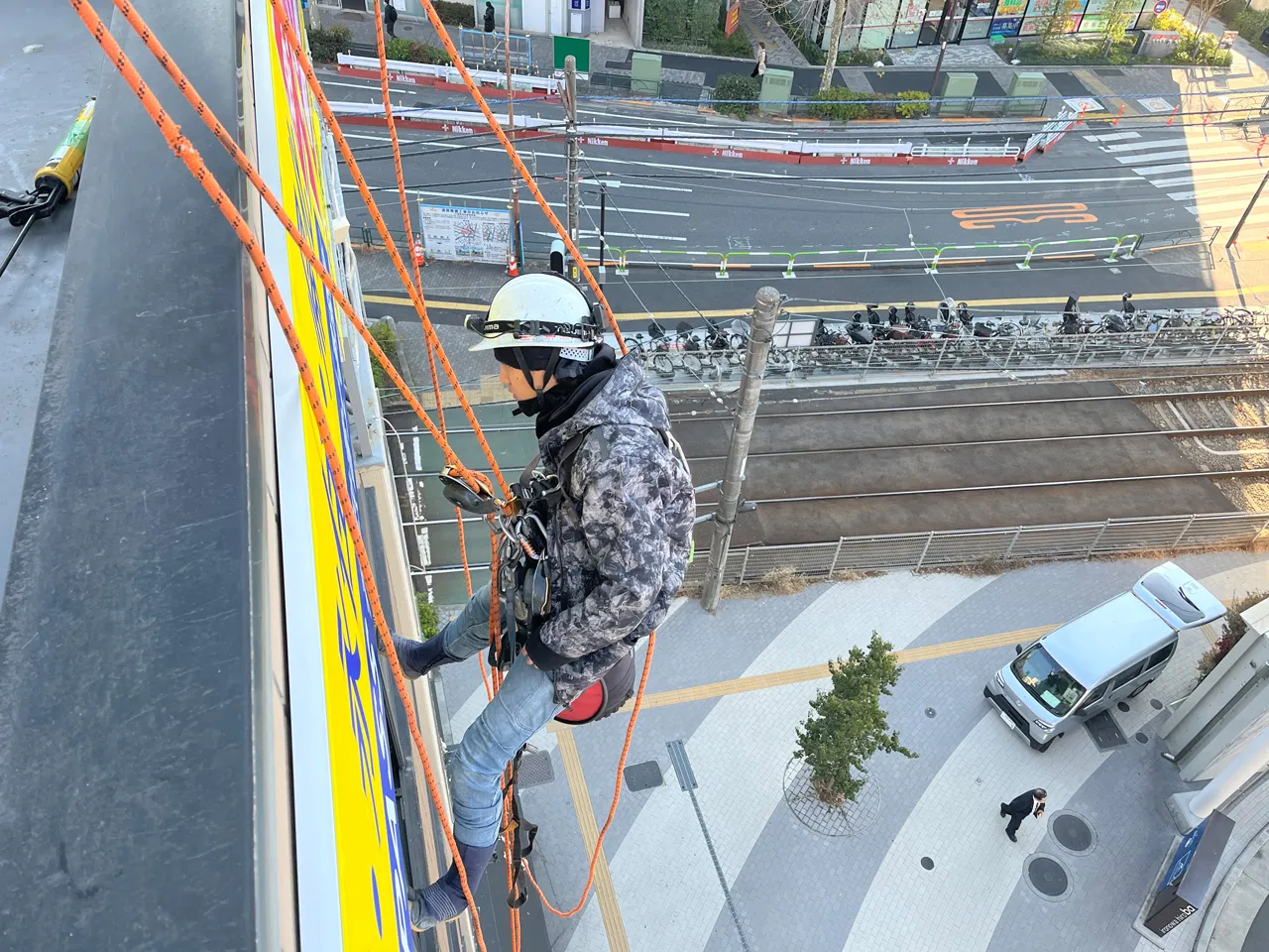 ロープアクセス作業中の看板職人