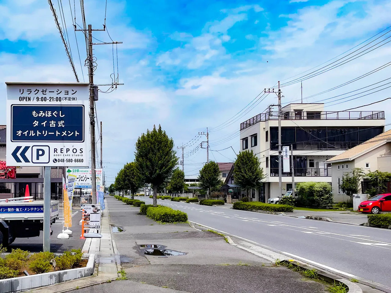 道路から見るボディケアスタジオ REPOS（ルポ）様の野立看板