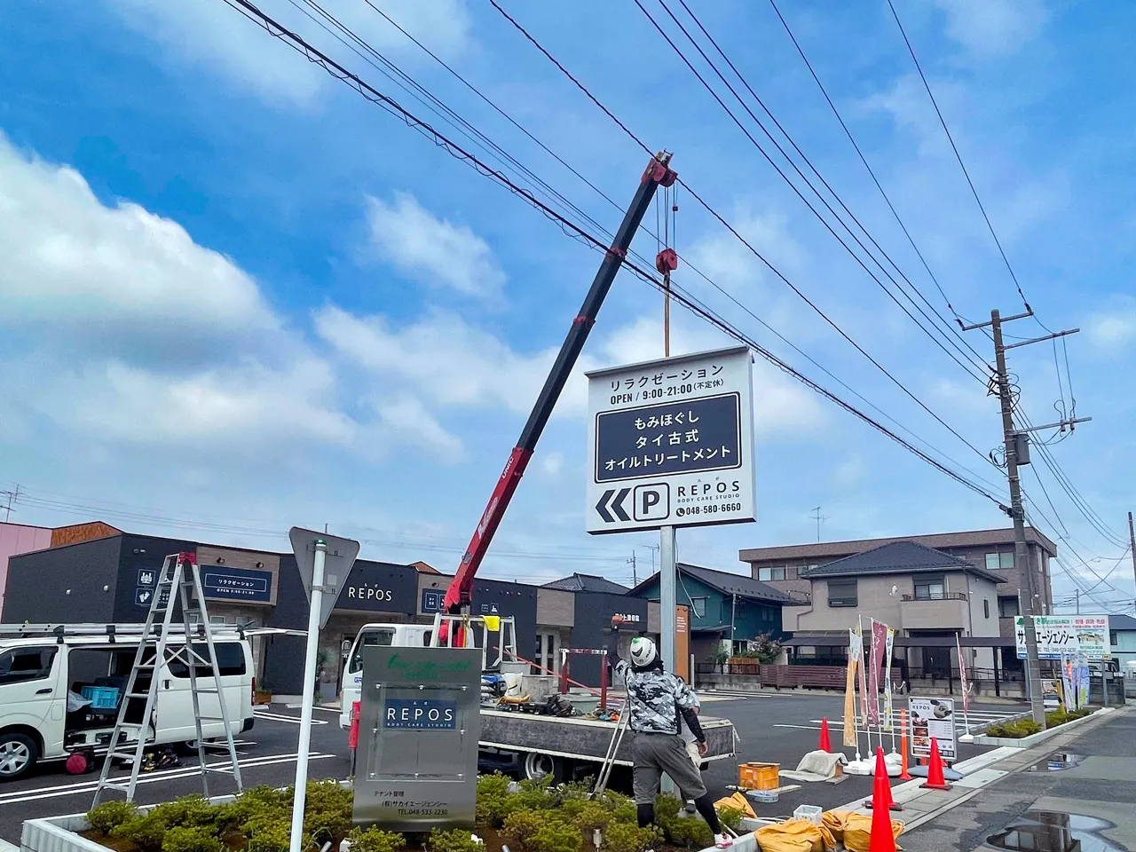 ユニック車で吊り上げられた自立看板