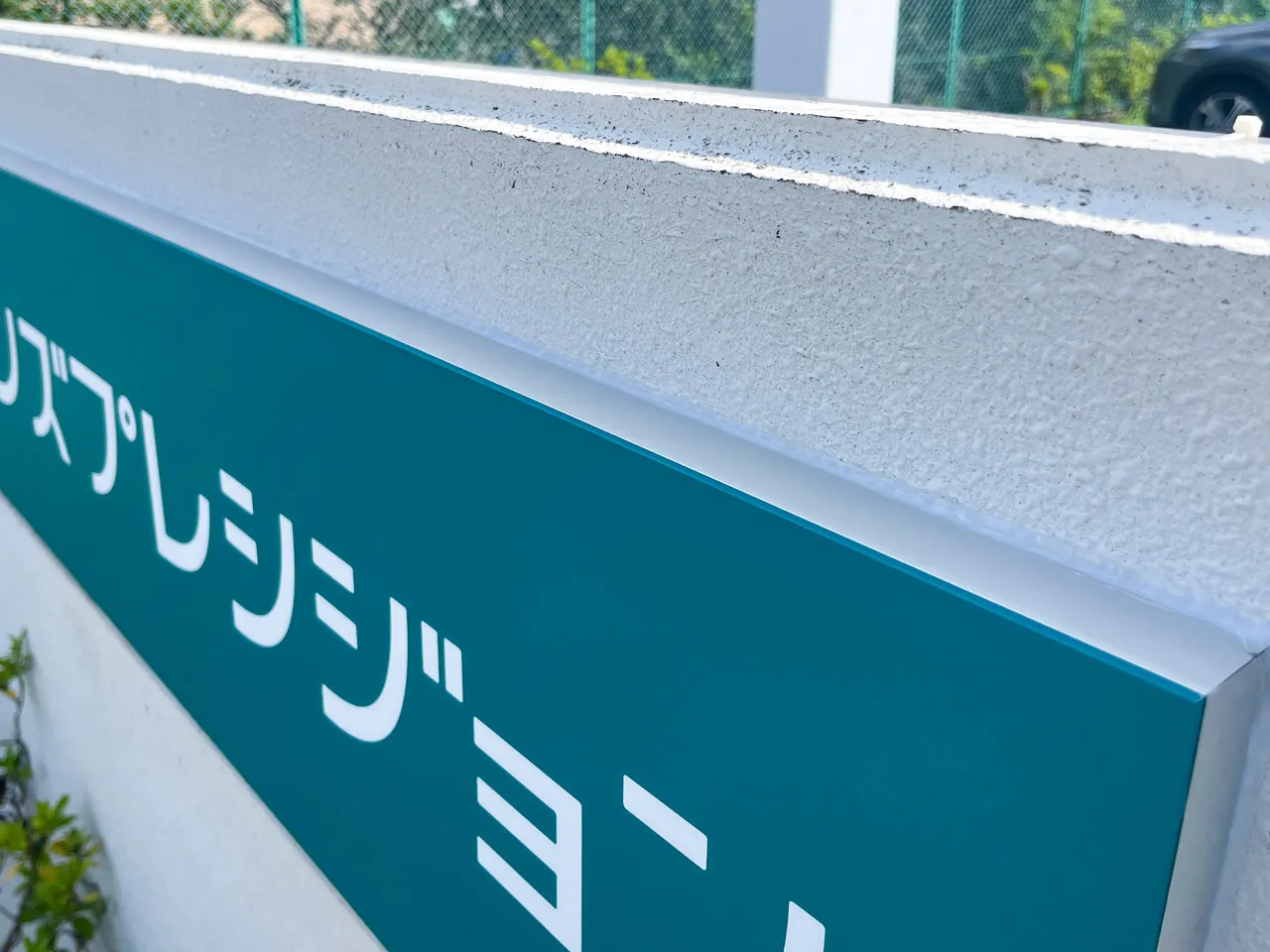 旧社名の銘板に新しい看板をかぶせたところ