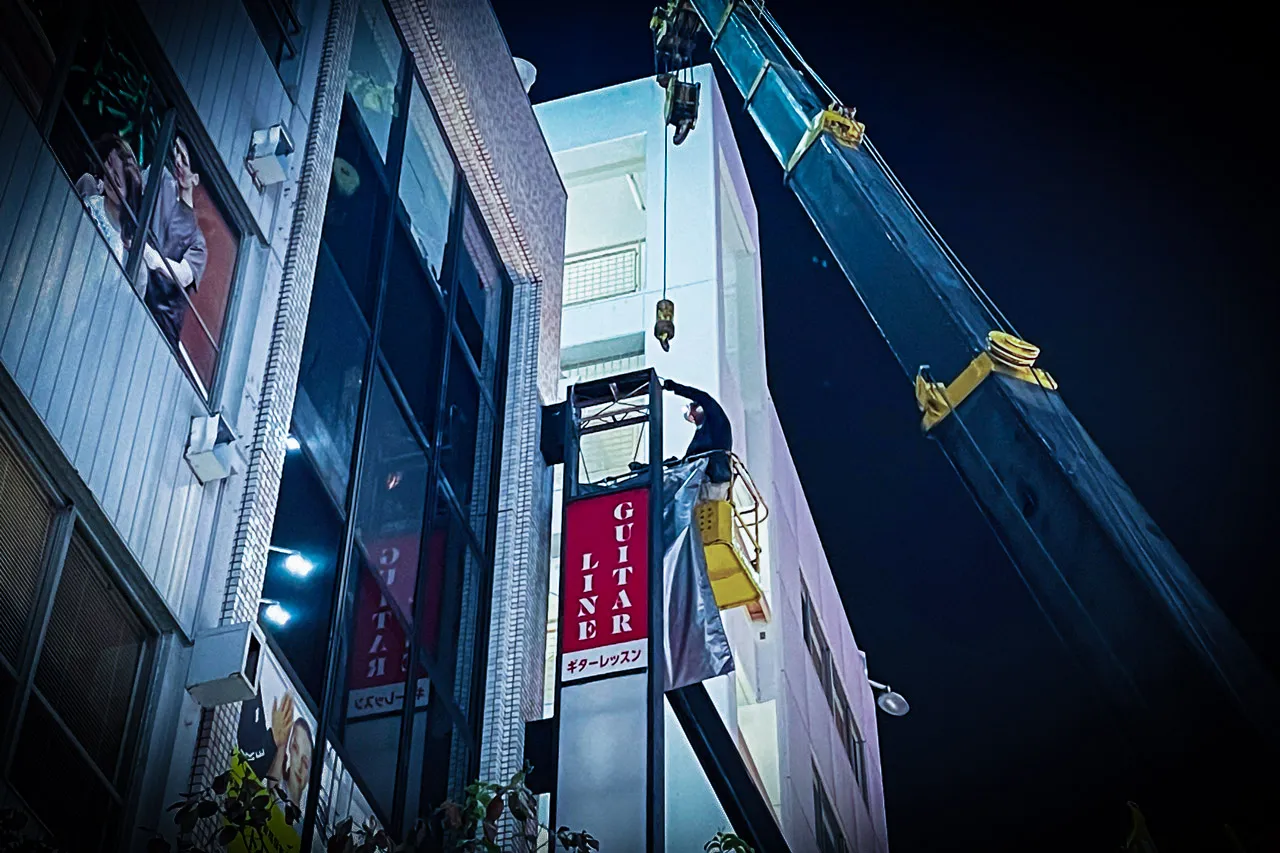 袖看板をクレーンで撤去するところ