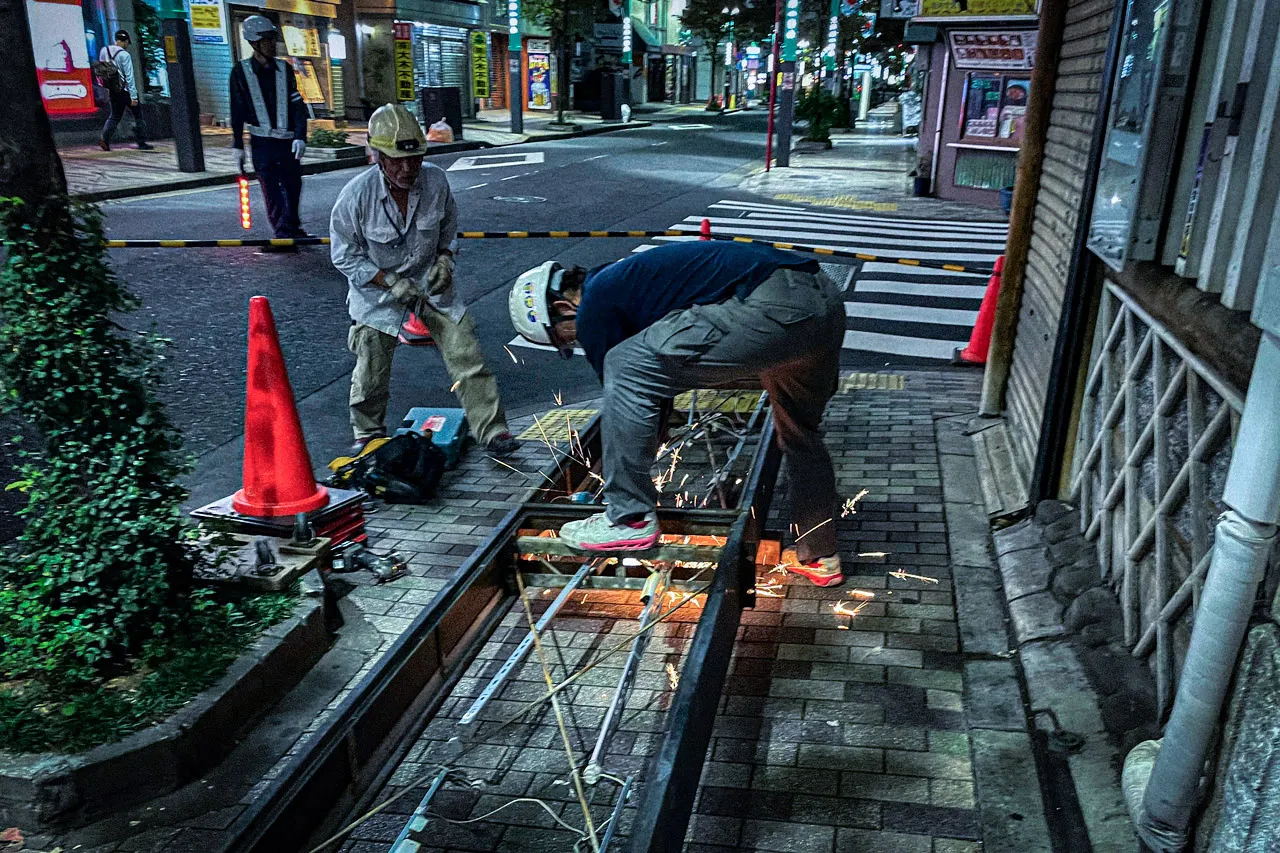 地上で袖看板を解体しているところ