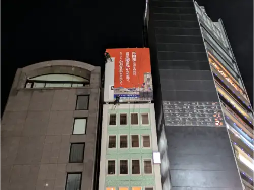 ロープアクセスで塔屋看板のシート貼替 | ヤシマ工業株式会社