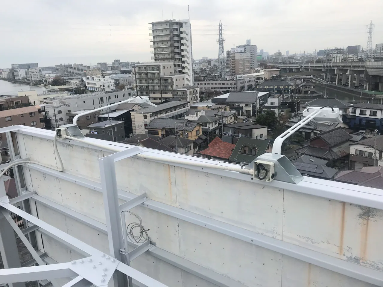 高所作業車を使った塔屋看板のシート貼り