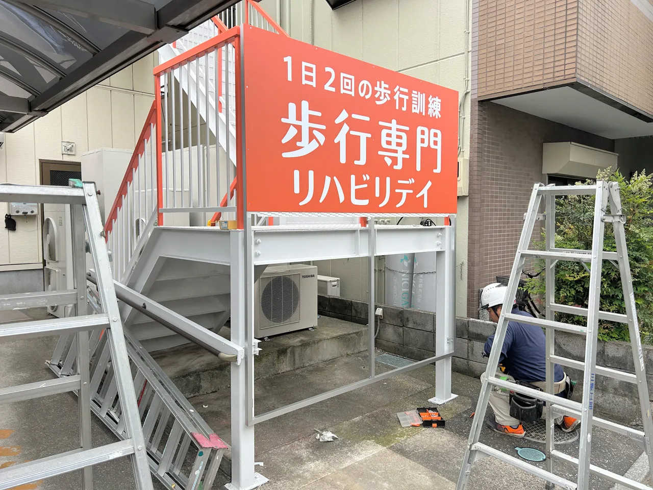 階段の手すりを利用した看板